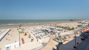 Um hotel à beira-mar com vários quartos, um pátio central e vista para a praia e o oceano.