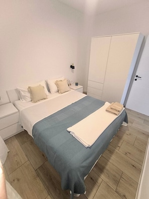 A bedroom with a bed, nightstand, wardrobe, and a door. - Aparment with Private Pool ,Shades of blueMM (Imotski)