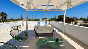A rooftop terrace with a pool, outdoor seating, and string lights. - Villa Aroi just a stone's throw from the sea! (Sicilia)