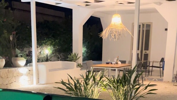 A swimming pool with a hot tub, surrounded by a white pergola and potted plants. - Villa Aroi just a stone's throw from the sea! (Sicilia)