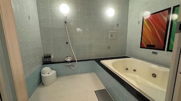 A bathroom with a bathtub, a toilet, and a shower.