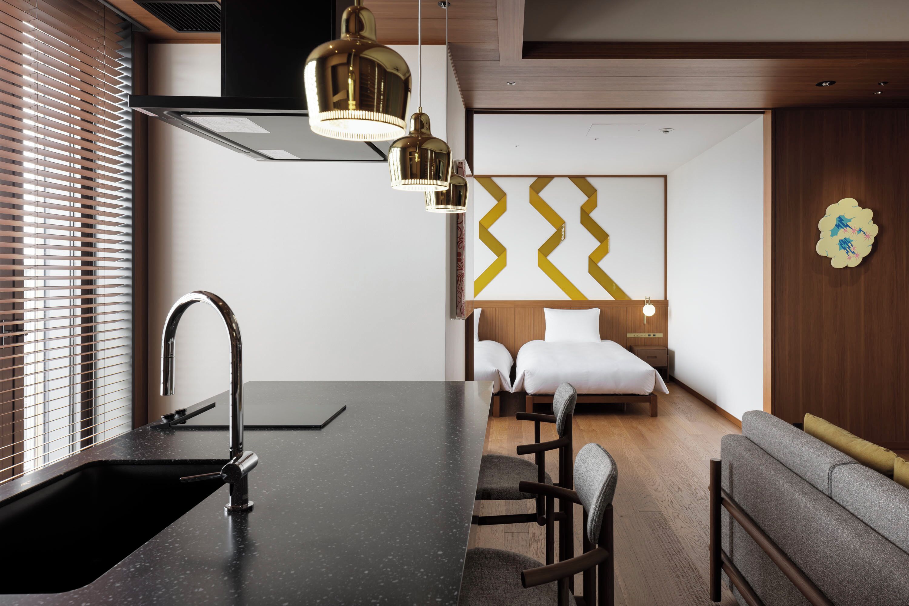 Una habitación de hotel moderna con cocina, una mesa de comedor y un sofá.