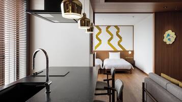 Una habitación de hotel moderna con cocina, una mesa de comedor y un sofá.