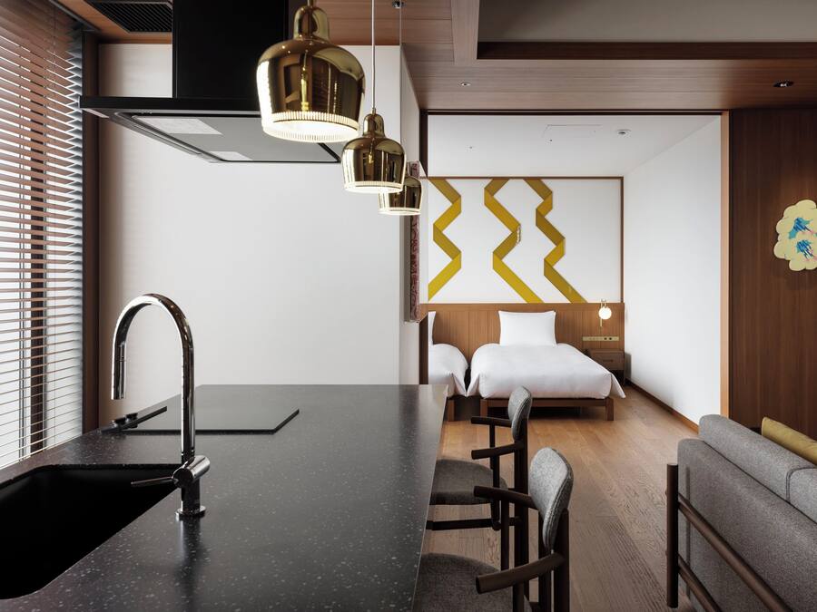 Una habitación de hotel moderna con cocina, una mesa de comedor y un sofá.