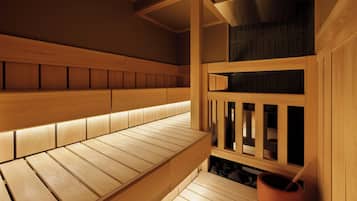 A wooden sauna with benches and a stone basin.