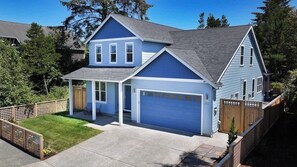 A two-story house with a blue exterior and a garage.