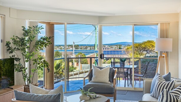A spacious balcony with a view of a coastal area, including a bridge and solar panels. - Baywatch 3 - Best Location & A View! (Merimbula)
