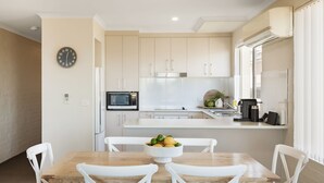 A modern kitchen with white cabinetry, a microwave, and a coffee machine. - Baywatch 3 - Best Location & A View! (Merimbula)