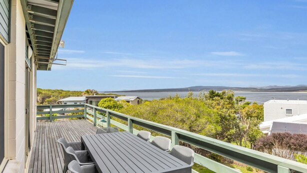 A wooden deck with outdoor seating, overlooking a body of water and distant hills. - Cliffhanger - Pet Friendly! (Merimbula)