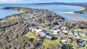 Vista aérea de una zona residencial costera con casas, caminos y una playa.