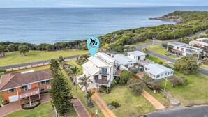 A residential area with houses, a road, and a view of the ocean. - Our Beach House - with ocean views! (Merimbula)