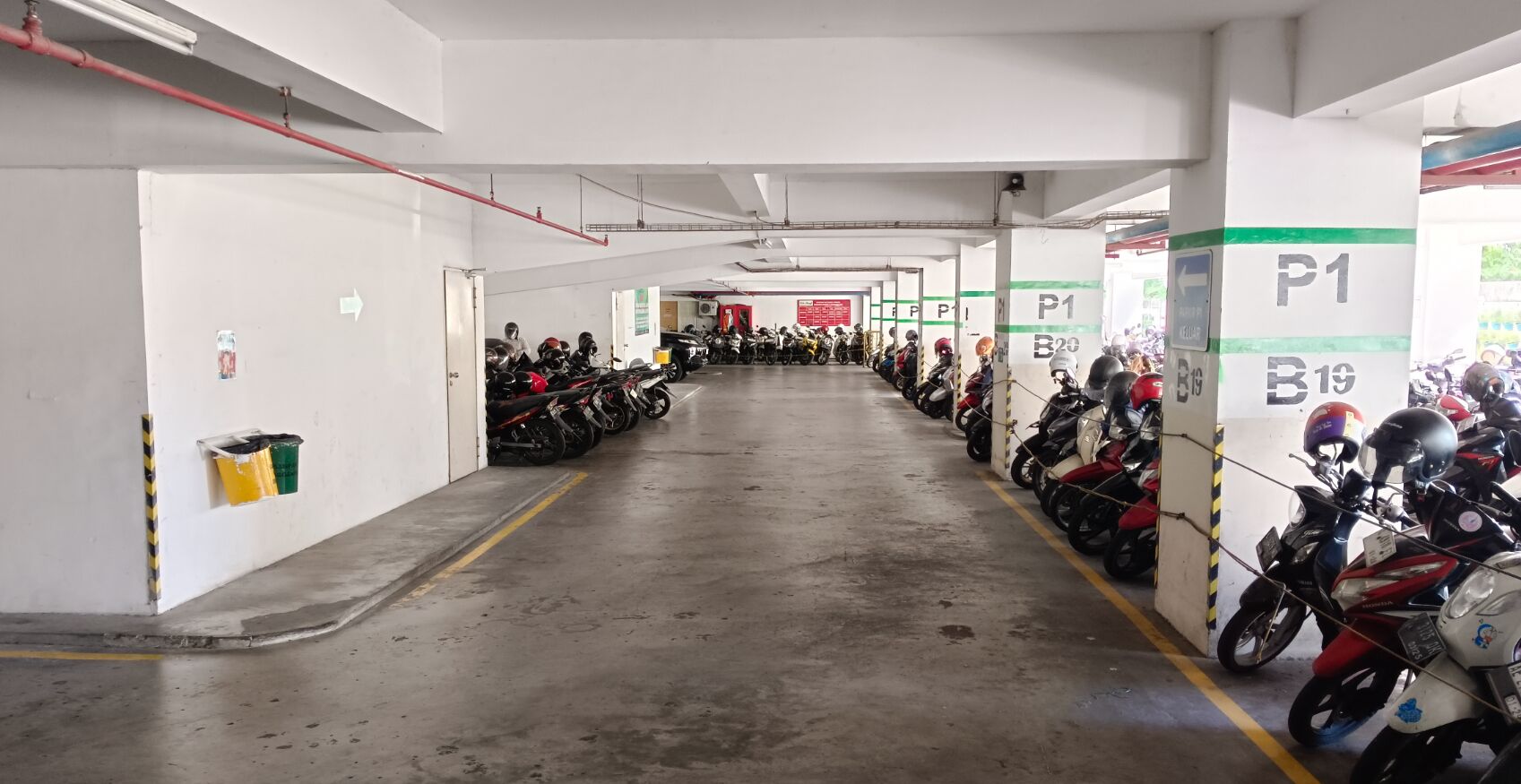 A multi-level parking garage with rows of motorcycles parked on both sides.