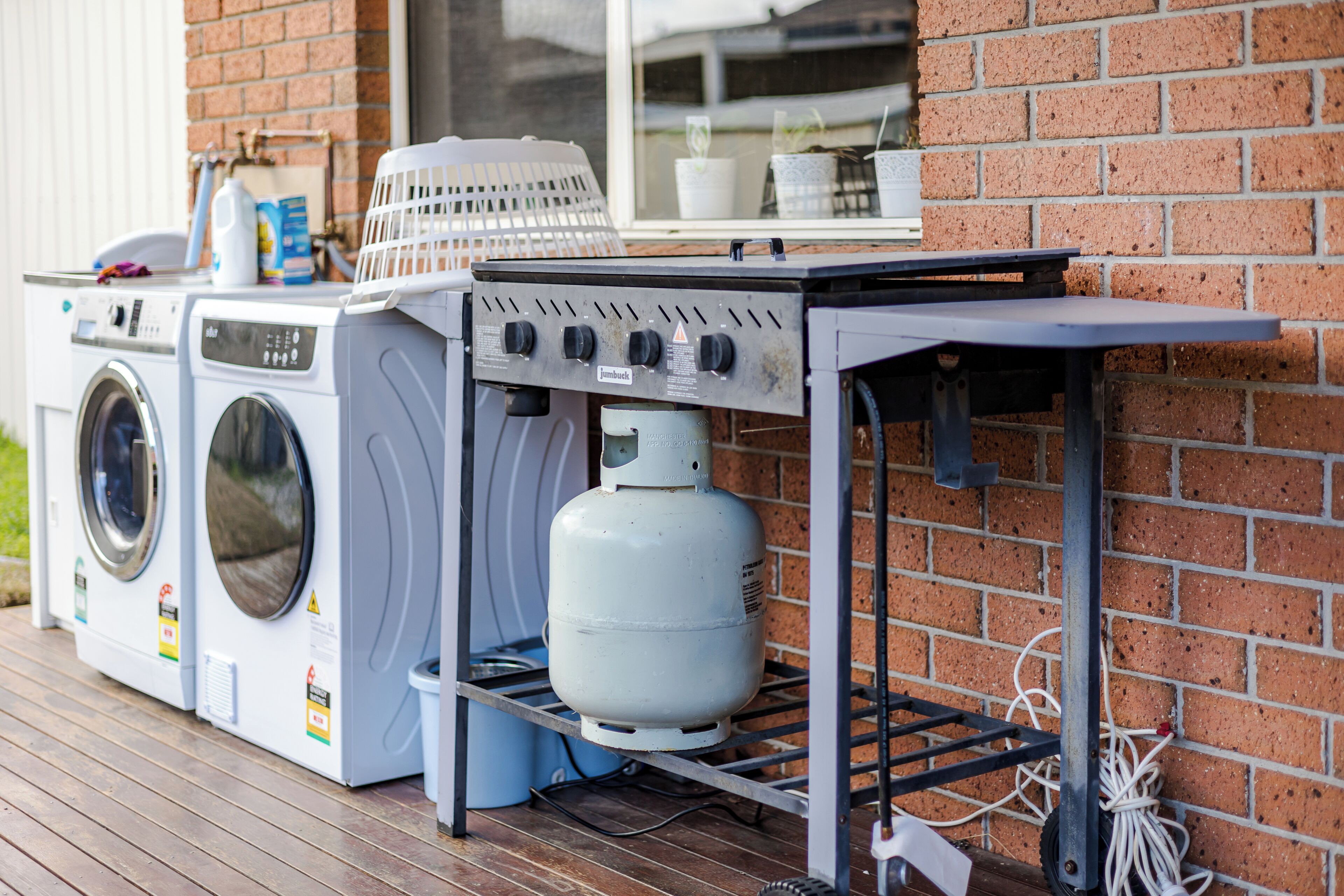 A laundry area with two washing machines and a gas stove.