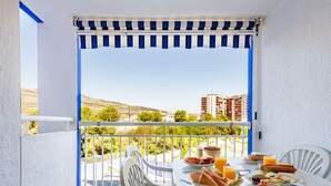A balcony with a table set for breakfast, overlooking a scenic view of buildings and greenery. - Mar de Oropesa II by Interhome (Oropesa del Mar)