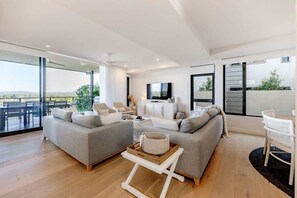 Un soggiorno moderno con un divano, un tavolino da caffè e una televisione.
