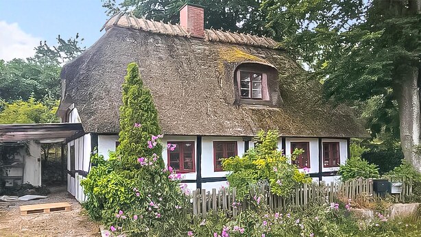 A traditional thatched-roof house with white walls and a wooden fence. - 1 bedroom awesome home in Rudkøbing (Rudkøbing)