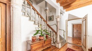 Eine Treppe mit weißen Säulen, Holzstufen und einem roten Teppich.