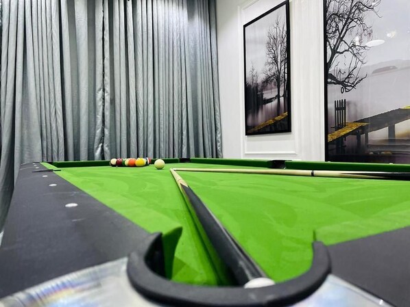 A pool table with balls and a cue stick, a window with curtains, and a framed picture on the wall. - Vic & J Lounge and Hotel (Asaba)