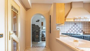A kitchen with a tiled backsplash, a stove, and a countertop. - Appartamento Casa Tre Colli (Trentino-Alto Adige)