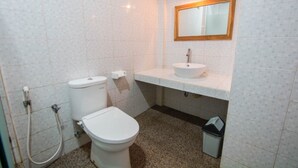 Une salle de bain avec des toilettes, un lavabo et un miroir.