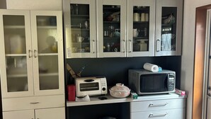 A kitchen with white cabinets, a microwave, a toaster, and a sink. - Guesthouse Aizu - Hostel (Tanabe)