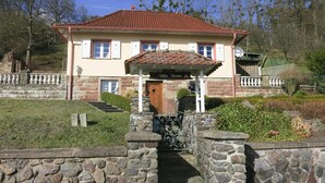 Un bâtiment à deux étages, avec un toit recouvert de tuiles rouges, une façade en pierre et une enseigne indiquant « Villa Roma ».