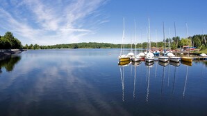Un lac paisible où plusieurs bateaux sont amarrés le long de la rive.