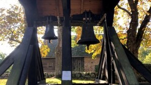 A bell tower with two bells, surrounded by trees and a stone wall. - Apartment in Trassenheide for 4 Personen (Trassenheide)