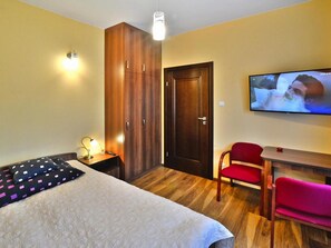Relax in this inviting space with a large bed, wardrobe, and comfortable seating area.