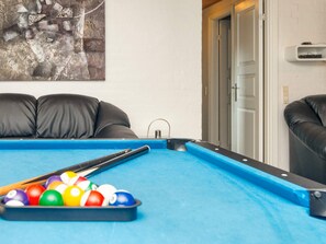 A pool table with balls, a cue stick, and a painting on the wall. - 4 Star Holiday Home in Ulfborg (Ulfborg)