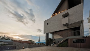 Un edificio moderno con el nombre 'Adelvilla' bien visible en la fachada.