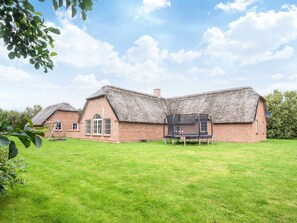A thatched-roof house with a trampoline in the yard. - 4 Star Holiday Home in Ulfborg (Ulfborg)