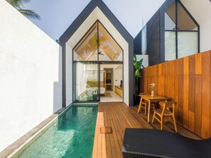 A modern house with a swimming pool, wooden deck, and a dining area. - Tannari Villa Ubud (Ubud)