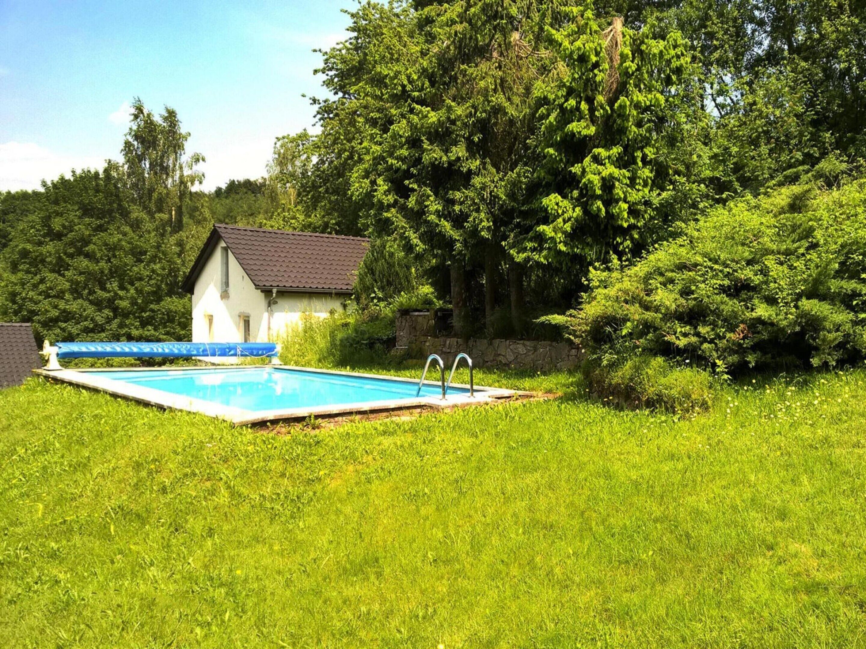 A swimming pool with a house in the background.