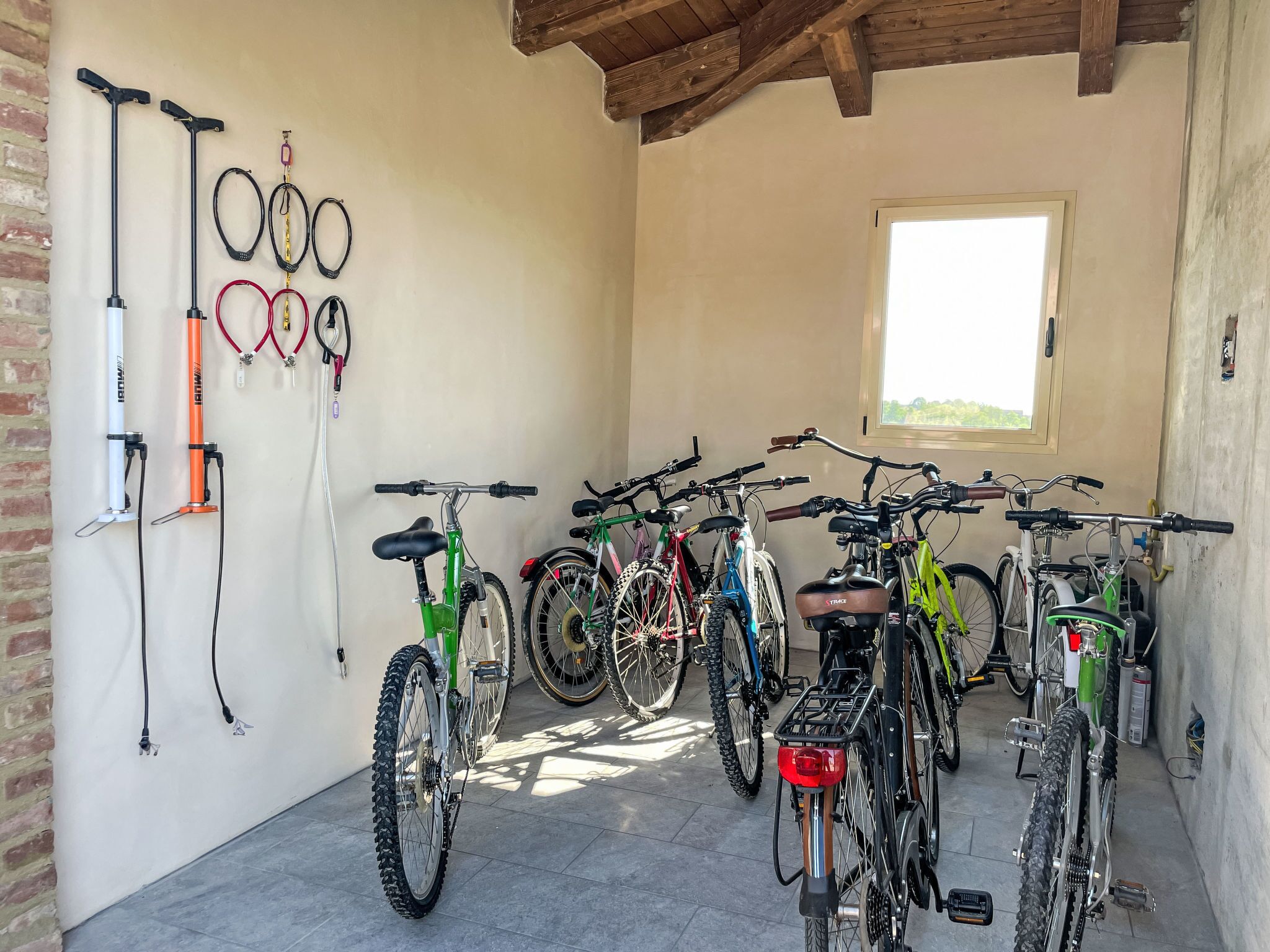 A room with bicycles and various bike accessories like helmets and pumps.