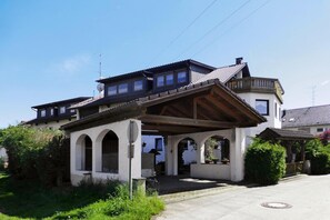 A two-story house with a covered porch, a satellite dish, and a garage. - Apartment in Langenargen Near Lake Constance (Langenargen)