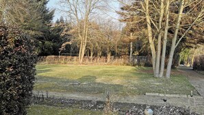 A grassy area with trees and a fence. - Twin Bungalow at Black Lake, Schwarz (Schwarz)