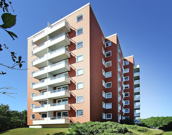 A multi-story residential building with balconies, large windows, and a brick facade. - Ferienwohnung, St. Peter-ording (St. Peter-Ording)