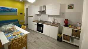 A compact kitchen with white cabinets, a wooden countertop, and a modern pendant light. - A stone's throw from the historic Ballaró market and the historic center of Palermo (Palermo)