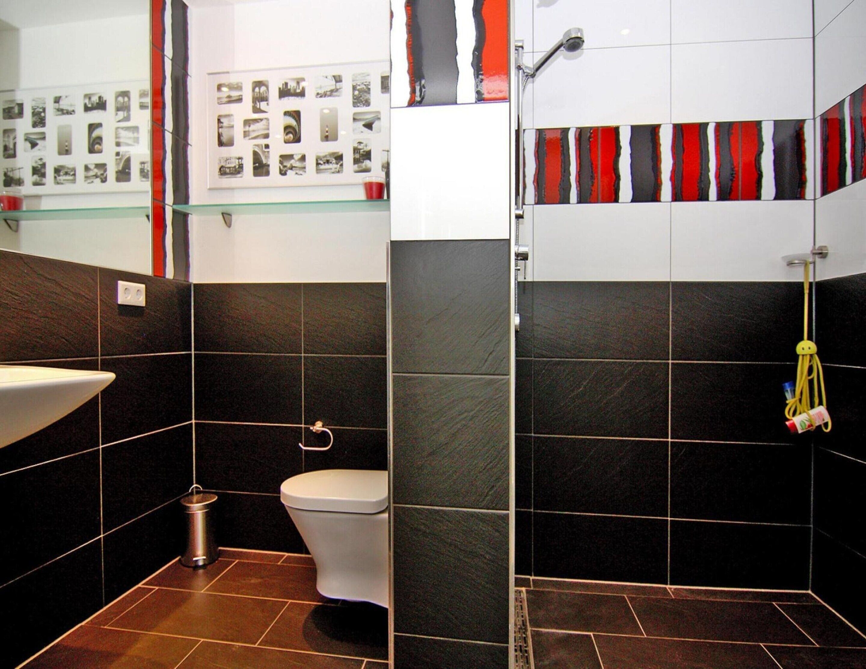 A modern bathroom with a toilet, sink, and shower area.