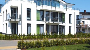 A modern two-story residential building with balconies, large windows, and a well-maintained lawn. - Appartementhaus Calmsailing, Borgerende (Boergerende-Rethwisch)