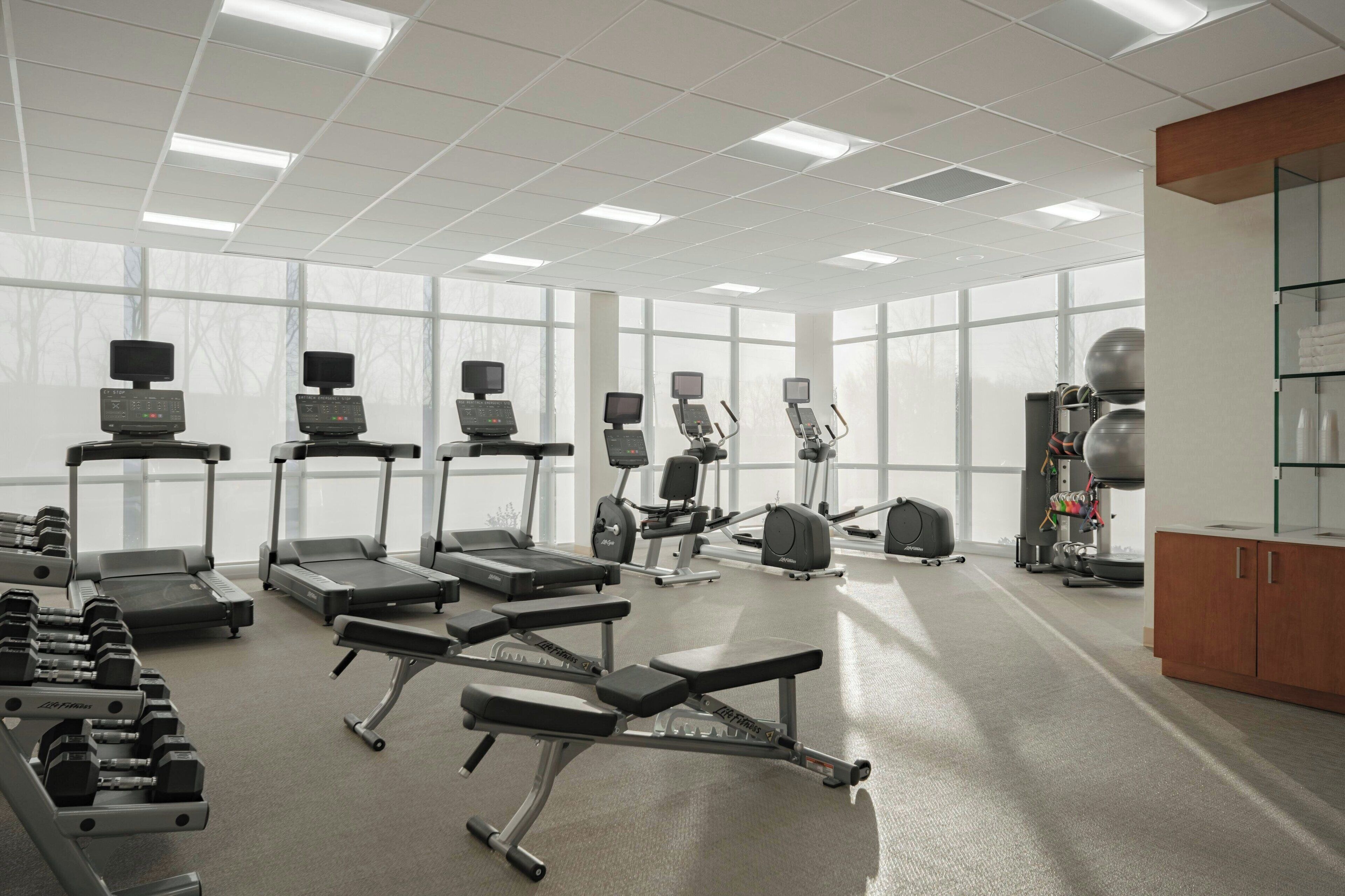 Una palestra con tapis roulant, ellittiche e pesi liberi.