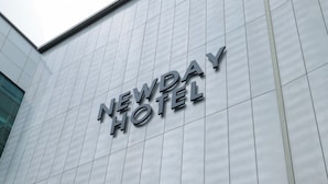 L’extérieur de l’hôtel Newday, avec son design moderne et son enseigne bien visible.