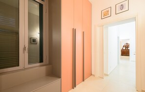 Ein Flur mit einer Schiebetür, Schränken und einem gerahmten Bild an der Wand.