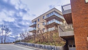 Ein modernes Gebäude mit mehreren Balkonen und einer Ziegel-Fassade.