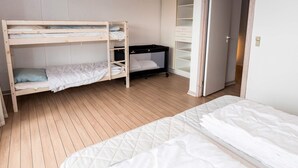 Quarto com beliche, escrivaninha e armário.