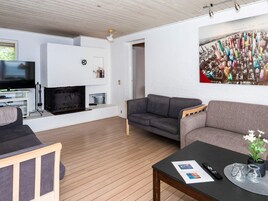 Una sala de estar moderna con chimenea, un sofá, una mesa de centro y un televisor.