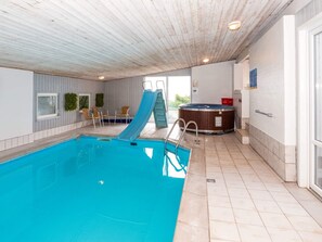 A swimming pool with a slide, a hot tub, and a seating area with chairs. - 4 Star Holiday Home in Thyholm (Thyholm)