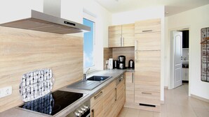 Una cocina moderna con estufa integrada, horno y campana extractora de acero inoxidable.