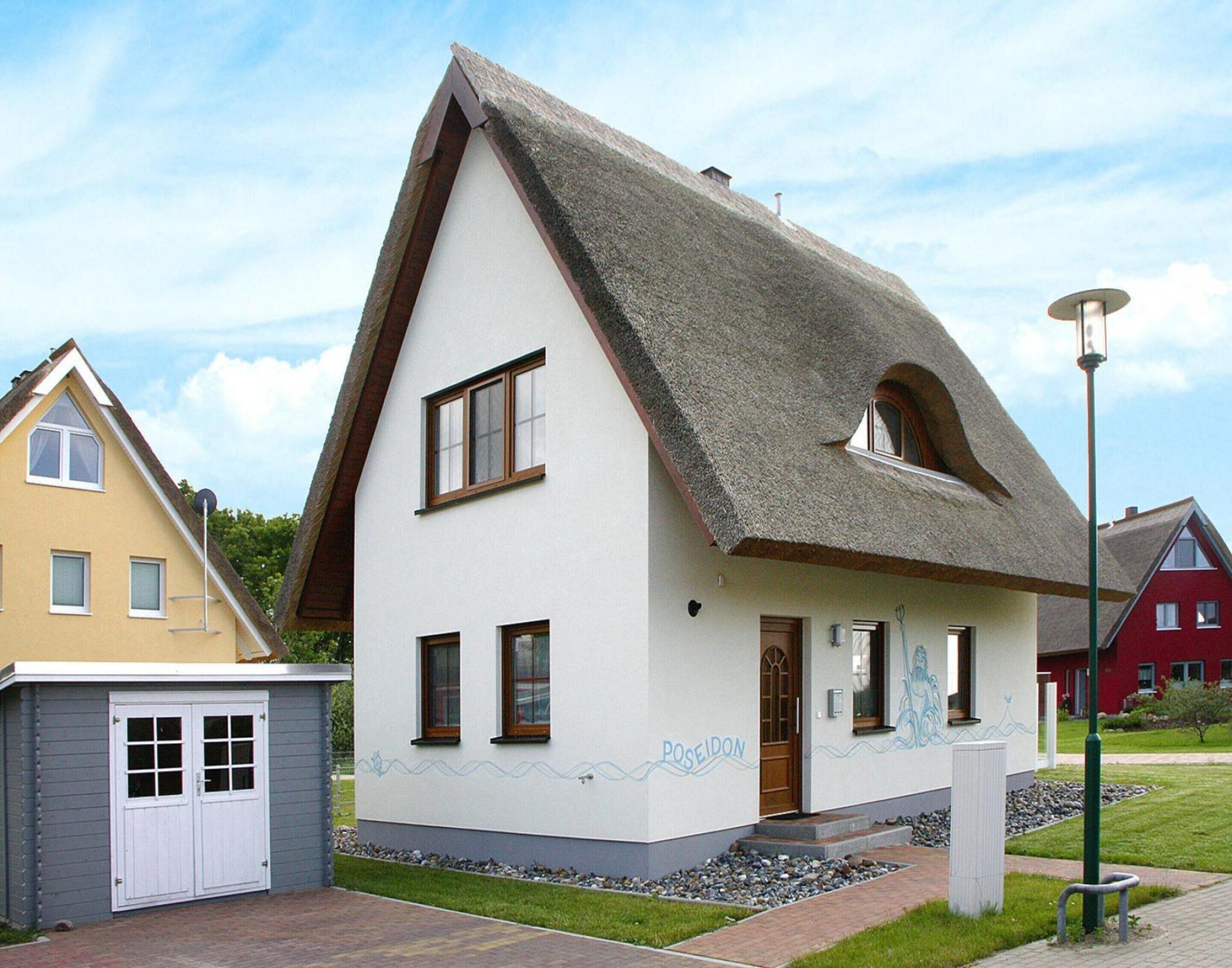 A two-story house with a steeply pitched roof and a small attached garage.